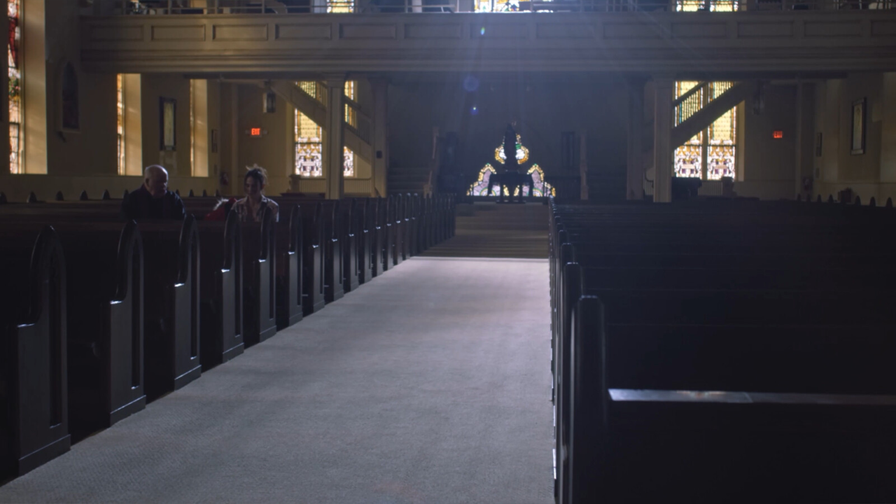 Two people sitting in an empty church